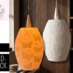 Puede incluir: Dos lámparas colgantes con diseños de mariposas. Una es naranja, la otra blanca. Las lámparas tienen forma de lágrima y están suspendidas del techo. El texto de la izquierda dice '.STL' y '3D-DRUCK'.