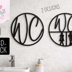 May include: Two circular black wall signs featuring the letters WC in a script font. One sign displays only the letters, while the other includes a horizontal line below the letters with two stylized human figures representing restroom icons.