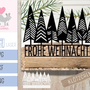 May include: A black metal Christmas tree forest silhouette with the German phrase "Frohe Weihnachten" on a wooden base. Includes a small wooden sign that says "KLÖTZCHEN".