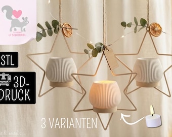 May include: Three hanging star-shaped frames made of thin light-colored material, each holding a white ribbed cylindrical candle holder. The frames are decorated with dried orange slices and green leaves, suspended by twine with a small wooden tag.
