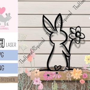 Op de afbeelding: Zwart metalen konijn silhouet met een bloem, tegen een houten achtergrond met bloemmotieven. De afbeelding bevat de tekst "The Home of Squirrel" en lasergesneden bestandsformaten .SVG en .PNG.