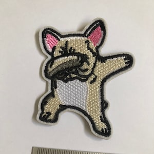 Puede incluir: Parche bordado termoadhesivo de un bulldog francés beige haciendo el dab. El parche mide aproximadamente 5 cm de alto y 6,5 cm de ancho.