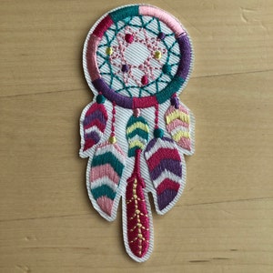 May include: A colorful embroidered dreamcatcher patch with pink, purple, green, and yellow feathers.