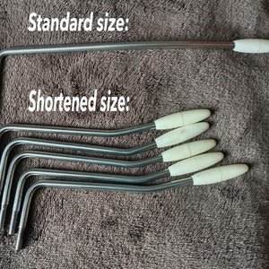 May include: A set of six guitar tremolo arms, with one standard size and five shortened sizes. The arms are made of metal and have a white plastic tip.