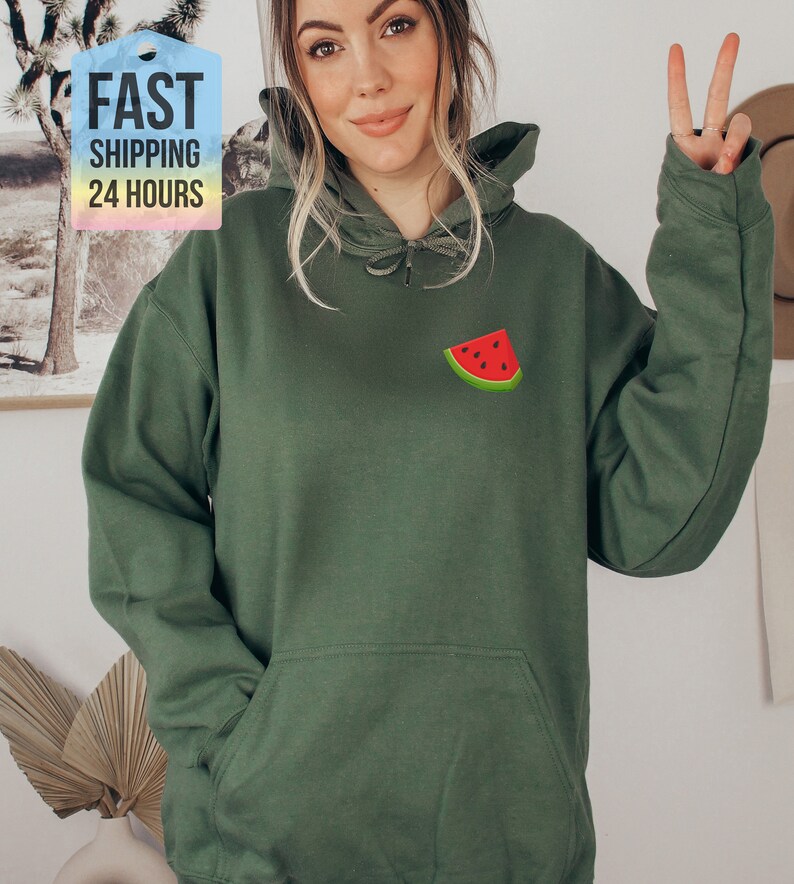 May include: A green hooded sweatshirt with a watermelon graphic on the front. The sweatshirt has a drawstring hood and a kangaroo pocket.