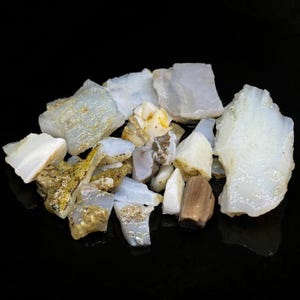 May include: A collection of white and brown opal rough stones. The stones are various shapes and sizes.