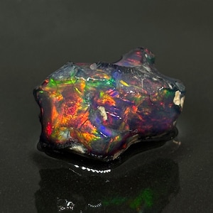 Ópalo etíope en bruto con volutas de color negro imagen 1