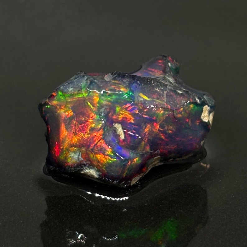 Ópalo etíope en bruto con volutas de color negro imagen 1