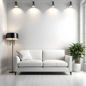 May include: A white leather sofa with a pillow sits in a white room with a black floor lamp and a potted plant. The room has a white ceiling with four recessed lights.