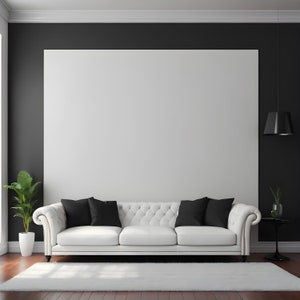 May include: A white tufted sofa with black throw pillows sits in front of a large white wall, against a black wall. A small plant is in a white pot on the left side of the sofa. A black pendant light hangs from the ceiling.