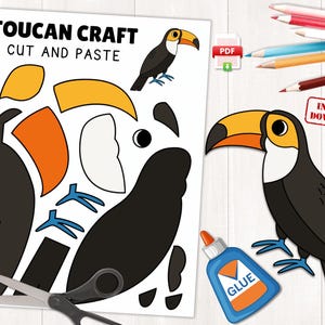 Può includere: Un kit artigianale di tucani con istruzioni per tagliare e incollare. Il kit include un foglio con parti del corpo del tucano, un'illustrazione del tucano finito e un flacone di colla. Il tucano ha un corpo nero, petto bianco e un grande becco arancione e giallo.