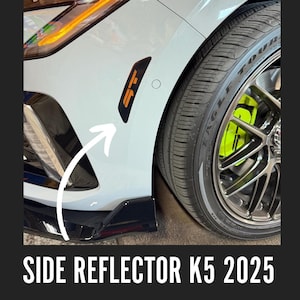 May include: Black side reflector with orange detailing and "GT" lettering on a white car. The car features a black front spoiler, a tyre with a silver rim, and a lime green brake caliper. The text "SIDE REFLECTOR K5 2025" is at the bottom.