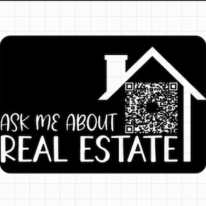 May include: A rectangular black sign featuring a white outline of a house shape. Inside the house outline is a square QR code. The text "ASK ME ABOUT" appears above the word "REAL ESTATE" in a white, sans-serif font on the black background.