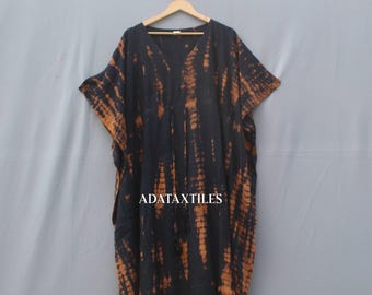 May include: A black and orange tie-dye caftan dress with a V-neck and short sleeves. The dress is hanging on a wooden hanger. The text "ADATAXTILES" is visible on the dress.