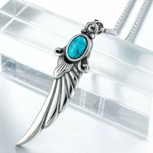 Op de afbeelding: Een zilveren ketting met een hanger in de vorm van een vleugel met een turquoise steen.