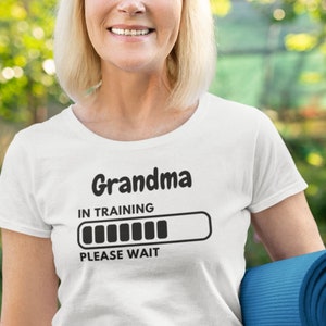May include: White t-shirt with the text "Grandma in training" and a progress bar that says "Please wait".