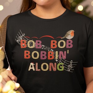 Envoke Your Christmas Spirit with our Festive &#39;Bob Bob Bobbin&#39; Along&#39; T-Shirt Retro Design with Playful Robin and Musical Notes