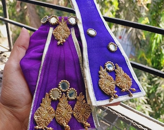 May include: Purple fabric with gold embellishments and mirrored accents. The fabric is folded and has a decorative trim.