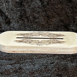 Könnte beinhalten: Ein Holzsockel mit einem dekorativen Laser-Schnittmuster. Der Sockel besteht aus mehreren Schichten Sperrholz und hat eine natürliche Holzoptik.