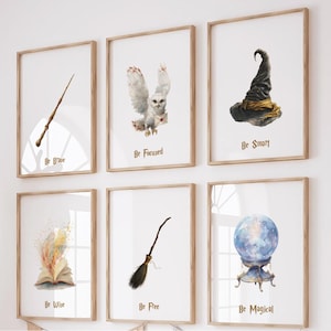 May include: A set of framed art prints with a wizard theme, including a wand, owl, sorting hat, open book, broom, and crystal ball. The prints are above a storage unit labelled "nursery wizard collection."
