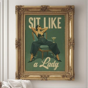 Puede incluir: Un estampado vintage enmarcado con el texto "SIT LIKE a Lady" sobre un fondo verde. La obra de arte representa a una mujer con gafas de sol, vestida de negro y con tacones, relajándose en una silla con un cóctel. El marco es dorado y ornamentado.