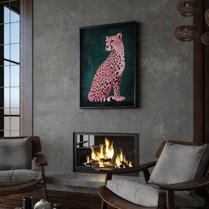 May include: A framed print of a pink cheetah sitting on a green background. The cheetah is facing to the right and has black spots. The frame is black and has a white mat.