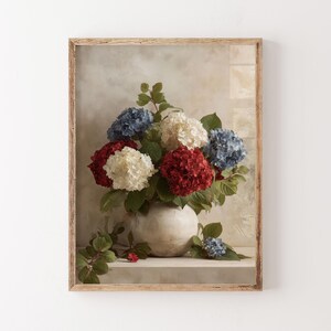 Pu&ograve; includere: Una stampa incorniciata di una natura morta floreale. L'opera presenta un vaso pieno di ortensie rosse, bianche e blu. I fiori sono ambientati su uno sfondo neutro e la cornice &egrave; in legno chiaro.