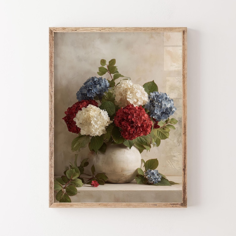 Pu&ograve; includere: Una stampa incorniciata di una natura morta floreale. L'opera presenta un vaso pieno di ortensie rosse, bianche e blu. I fiori sono ambientati su uno sfondo neutro e la cornice &egrave; in legno chiaro.