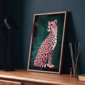May include: A framed print of a pink cheetah sitting in a green jungle setting. The cheetah is facing to the left and has black spots.