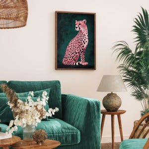 May include: A pink cheetah with black spots sitting on a dark green background. The cheetah is looking to the left of the image. The image is framed in a wooden frame.