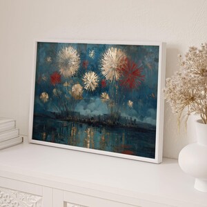 Pu&ograve; includere: Una stampa artistica incorniciata raffigura uno spettacolo pirotecnico sopra uno specchio d'acqua. L'opera presenta scoppi dorati, rossi e bianchi contro un cielo blu scuro. L'acqua riflette le luci e uno skyline &egrave; visibile in lontananza.