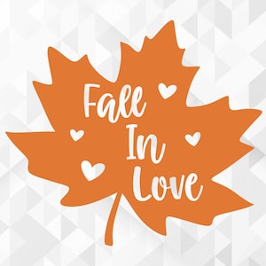 Può includere: Una foglia d'acero arancione con il testo "Fall in Love" in lettere bianche. Ci sono quattro piccoli cuori bianchi intorno al testo.