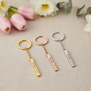 Könnte beinhalten: Ein Set aus drei Keramikbechern mit gesprenkelter, matter Oberfläche. Die Becher sind in Creme-, Hellgrau- und Dunkelgrautönen gehalten. Jeder Becher hat ein schlichtes, minimalistisches Design.