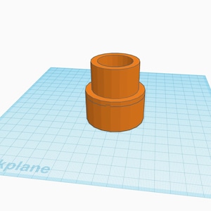 May include: An orange plastic connector with a cylindrical shape. The connector has a smooth surface and a slightly raised lip around the top edge.