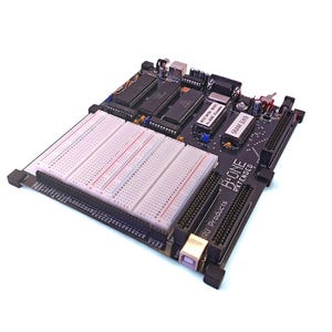 May include: A black circuit board with a white breadboard and various electronic components. The board has the text "B:ONE EXTENDED" and "RU Products". The breadboard has red and blue lines.