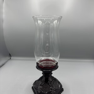 Könnte beinhalten: Eine weiße Keramik-Tasse mit schwarzem Henkel und dem Text "But First, Coffee" in schwarzer, fetter Schrift. Die Tasse steht auf einer weißen Oberfläche. Die Tasse ist etwa 10 cm hoch.