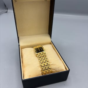 Rektangulär vintageklocka i guldfärg med svart urtavla