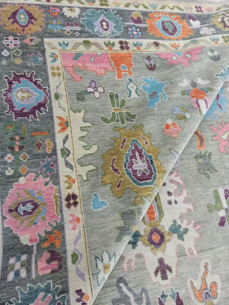 Pu&ograve; includere: Primo piano di un tappeto grigio con un motivo floreale colorato. Il tappeto ha uno sfondo grigio chiaro con una variet&agrave; di colori, tra cui rosa, blu, verde e giallo. Il motivo &egrave; intricato e dettagliato, e il tappeto &egrave; realizzato in un materiale morbido e lussuoso.