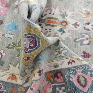 Pu&ograve; includere: Un tappeto grigio con un motivo floreale colorato. Il tappeto ha uno sfondo grigio chiaro con accenti rosa, blu, verdi e gialli. Il motivo &egrave; intricato e dettagliato, con una variet&agrave; di motivi floreali.