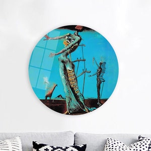 May include: A round, blue and green abstract painting featuring a woman with a long, flowing dress and a man standing behind her. The woman is holding her arms out to the side and the man is holding a staff. The painting is set against a blue background with a white cloud in the upper left corner.