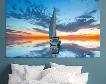 Könnte beinhalten: Leinwanddruck eines Segelbootes auf ruhigem Wasser bei Sonnenuntergang. Der Himmel wechselt von Blau zu Orange und Gelb und spiegelt sich im Wasser wider. Das Segelboot hat ein weißes Segel und einen blauen Rumpf, was eine ruhige nautische Szene schafft.