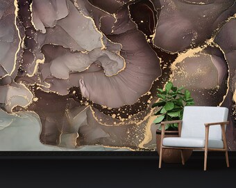 May include: Abstract wall art featuring a brown and gold marble design. The design has a swirling pattern with gold accents. The art is displayed in a room with a white chair and a potted plant.