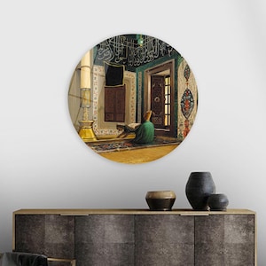 May include: A round painting depicting a person praying in a mosque. The mosque has intricate tile work and calligraphy on the walls. The person is wearing a green robe and is kneeling on a prayer rug.
