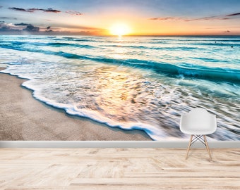 May include: A scenic beach scene with a golden sunrise over the ocean. The waves are crashing on the sandy shore, creating a beautiful and tranquil atmosphere.