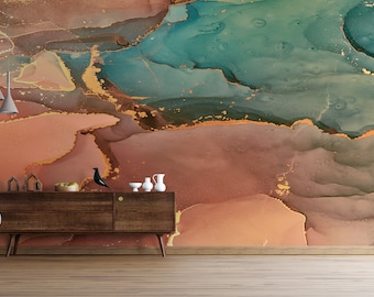 May include: An abstract wall mural with a blend of colors including teal, gold, and shades of brown and orange. A gray armchair, a wooden cabinet with decorative items, and pendant lights are in the foreground. The room has a wooden floor.