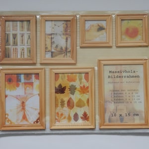 Könnte beinhalten: Ein Set mit 7 Holzbilderrahmen in verschiedenen Größen. Die Rahmen sind in einem Raster angeordnet und zeigen verschiedene Bilder, darunter eine Uhr, Schmetterlinge und Blätter. Die Rahmen sind aus massivem Holz gefertigt und haben eine natürliche Oberfläche. Das Set enthält 2 Rahmen mit den Maßen 15 x 20 cm, 1 Rahmen mit den Maßen 18 x 25 cm, 2 Rahmen mit den Maßen 23 x 28 cm und 1 Rahmen mit den Maßen 25 x 38 cm.