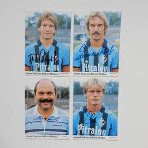 Könnte beinhalten: Vier Vintage-Sammelkarten mit Porträts von Fußballspielern in hellblauen Trikots mit schwarzen Akzenten. Jede Karte hat eine Unterschrift und den Text "Pitralon". Der Text "Immer frisch am Ball mit Pitralon" ist ebenfalls sichtbar.