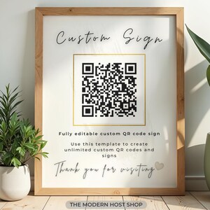 May include: A framed sign with a light wood border featuring the text Custom Sign at the top, a central black and white QR code inside a gold square, and the text Fully editable custom QR code sign, Use this template to create unlimited custom QR codes and signs, Thank you for visiting, and The Modern Host Shop at the bottom.