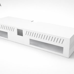 May include: A white rectangular architectural model labeled "MODEL A." The model has a long, low profile with rectangular cutouts and angled slits along the sides. A small square cutout is also present.