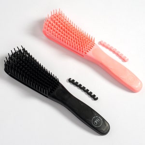 Peut inclure: Deux brosses à cheveux, une noire et une rose, avec un design démêlant. Les deux brosses ont un logo qui dit "For My Hair" et un accessoire de peigne ondulé et flexible.